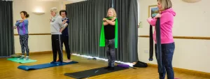 Small group Pilates in Broadstone. Performing exercises in a standing position.